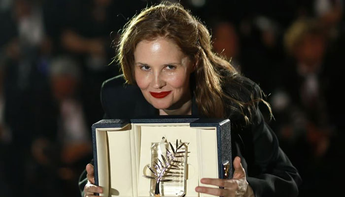 Justine Triet posing with the Palm dOr award which she received for her film Anatomy of a Fall