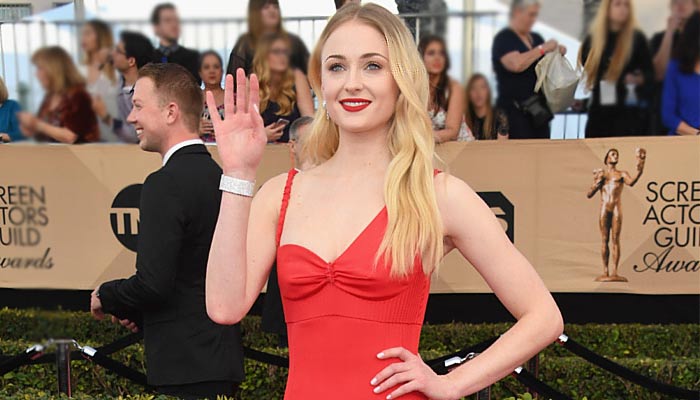 Sophie Turner welcomes Santa with a salute and elf head band