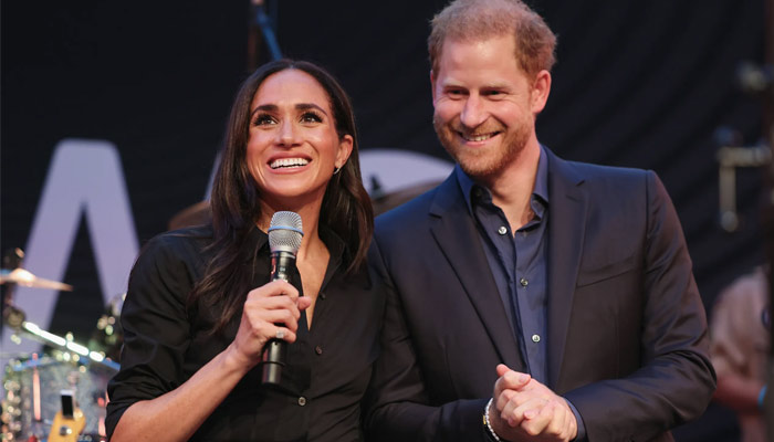 Meghan Markle donned a black dress at the red carpet as she walked hand in hand with Prince Harry