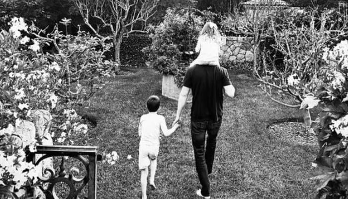 The candid shot shows Harry with Prince Archie walking by his side and Princess Lilibet perched on his shoulders