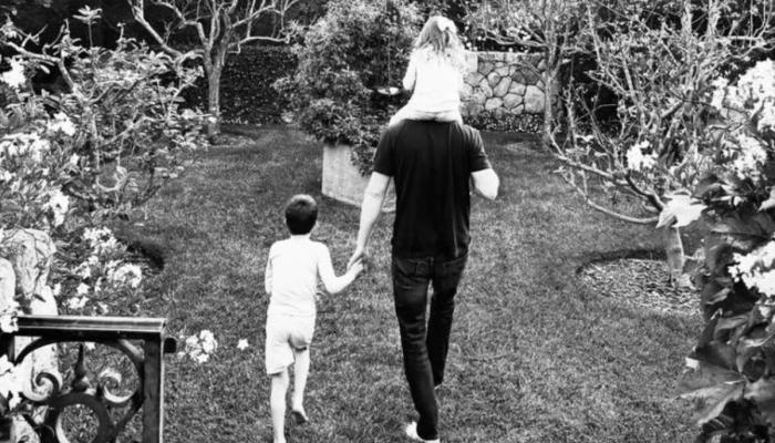 The photo shows Harry walking through the garden of their Montecito estate, carrying Lilibet